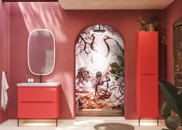 Badezimmer-Inspiration mit roten Wänden, sanft geformtem roten Waschtischunterschrank und Hochschrank, elegantem weißen Waschbecken und schönem ovalem Spiegel mit Beleuchtung, die zusammen mit der natürlichen Umgebung ein Vintage-Flair schaffen