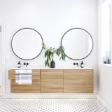 Nordisches Badezimmer aus Holz mit schönen runden Spiegeln mit schwarzen Kanten und viel Stauraum in den Badezimmermöbeln