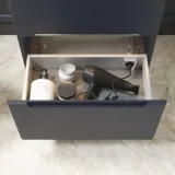 Badezimmer-Inspiration mit dunkelblauen Wandpaneelen, romantischer Blumen-Tapete, dunkelblauem Waschtischunterschrank mit weichen Formen und einem schönen runden Spiegel mit Beleuchtung, das ein Vintage-Flair verleiht