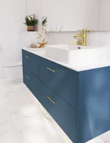 Badezimmer Inspiration mit Badezimmerschränken in moderner blauer Farbe, eleganter Aufsatzwaschbecken und großem quadratischem Spiegel mit Licht, weiße Fischgrätfliesen sorgen für einen stilvollen und klassischen Look