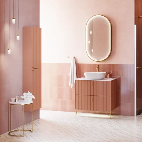 Großes Vintage-Badezimmer mit terrakottafarbenem Waschtisch, Aufsatzwaschbecken, ovalem Spiegel mit Messingrand, rosa und grauen Fliesen, romantisch und feminin