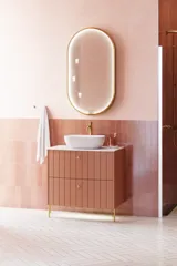 Großes Vintage-Badezimmer mit terrakottafarbenem Waschtisch, Aufsatzwaschbecken, ovalem Spiegel mit Messingrand, rosa und grauen Fliesen, romantisch und feminin