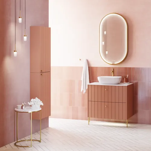 Großes Vintage-Badezimmer mit terrakottafarbenem Waschtisch, Aufsatzwaschbecken, ovalem Spiegel mit Messingrand, rosa und grauen Fliesen, romantisch und feminin