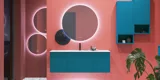 Große Badezimmerinspiration mit blauen Möbeln in Sonderfarbe mit Rillen, dünnem elegantem Waschbecken und schönen runden Spiegeln, roten Wänden und Terrazzoboden schaffen einen starken Kontrast zu den Möbeln und verleihen ein stilvolles, urbanes Aussehen.