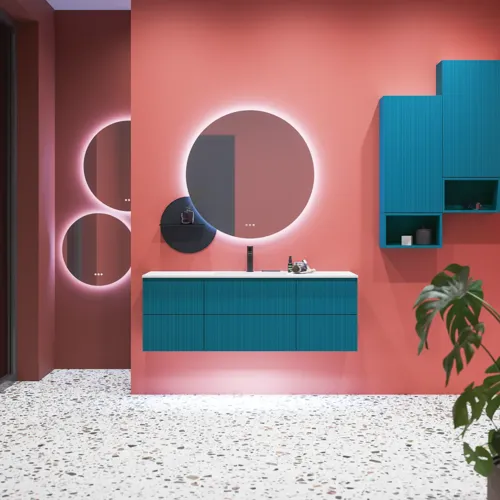 Große Badezimmerinspiration mit blauen Möbeln in Sonderfarbe mit Rillen, dünnem elegantem Waschbecken und schönen runden Spiegeln, roten Wänden und Terrazzoboden schaffen einen starken Kontrast zu den Möbeln und verleihen ein stilvolles, urbanes Aussehen.