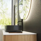 Minimalistische und stilvolle Badezimmer Inspiration mit Waschtischunterschrank, Unterschränken und Hochschränken aus goldener Eiche, großem rundem Spiegel mit Lichtsteuerung, farbigem WC und Aufsatzwaschbecken
