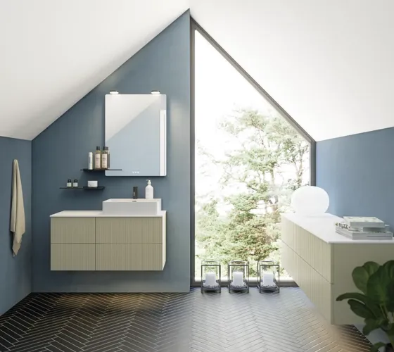 Badezimmer mit schräger Decke, beige Möbel mit Rillen, elegante Arbeitsplatte und quadratisches Waschbecken, schöner Spiegel mit Regalen, blaue Wände, große Fenster und schwarzer Fischgrätboden für ein helles, urbanes Aussehen.