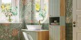 Badezimmerinspiration mit grünen Möbeln in Sonderfarbe mit Seiten aus naturbelassener Eiche, eleganten Rillen, stilvoller Arbeitsplatte mit ovalem Aufsatzwaschbecken, schönem ovalem Spiegel und Blumenmuster-Tapete für ein anmutiges, Retro-Aussehen.