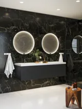 Elegante und moderne Badezimmer Inspiration mit dunklen Marmorwänden, runden beleuchteten Spiegeln mit schwarzem Rahmen, wandmontiertem Waschtischunterschrank mit Doppelwaschbecken und geräumiger Duschnische