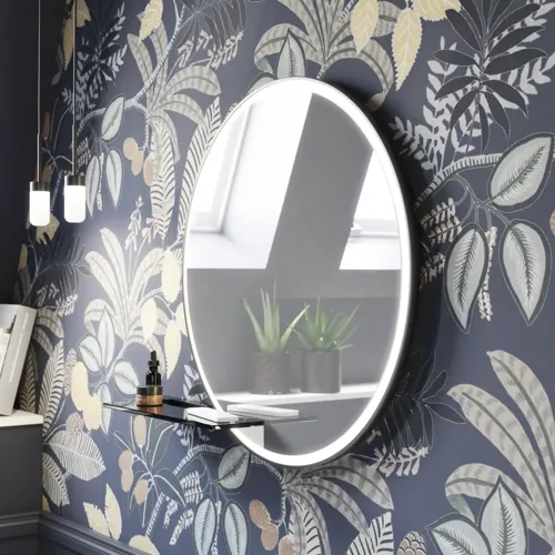 Badezimmer-Inspiration mit dunkelblauen Wandpaneelen, romantischer Blumen-Tapete, dunkelblauem Waschtischunterschrank mit weichen Formen und einem schönen runden Spiegel mit Beleuchtung, das ein Vintage-Flair verleiht