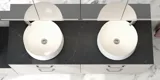 Romantische Badezimmer Inspiration mit Spiegelschrank, der praktische und anmutige Aufbewahrungslösungen bietet, doppelte Aufsatzwaschbecken auf einer Steinplatte.