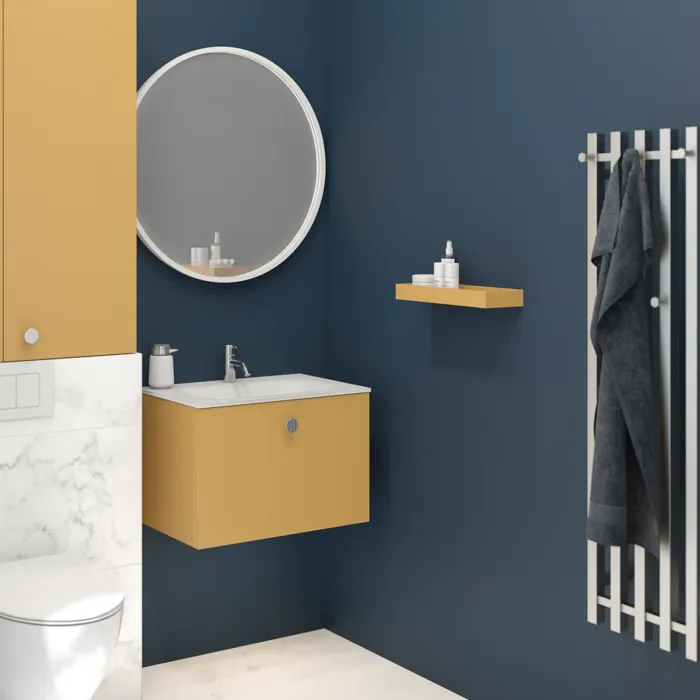 Kleines Badezimmer mit dunkelblauen Wänden und weichen Gelbtönen, rundem Spiegel und elegantem elektrische Handtuchwärmer.