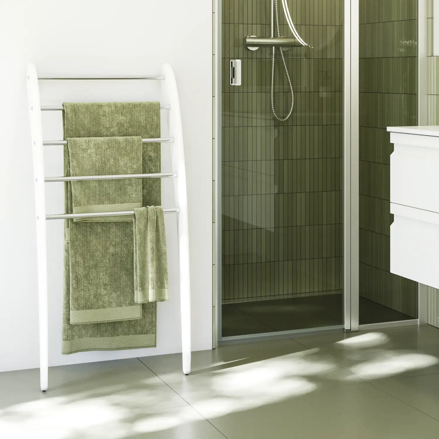 Badezimmerinspiration mit weißen Badmöbeln, elegantem Rundspiegel und Duschnische mit fester Duschwand mit Schwingtür aus Klarglas und Profilen aus satinierten, grünen Langfliesen sorgen für einen edlen Look.