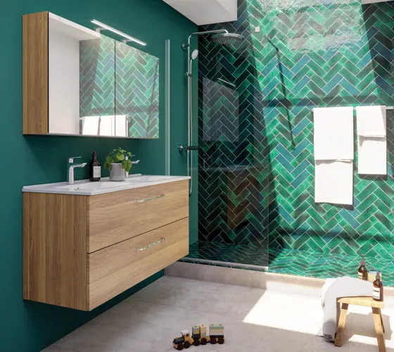 Großes Badezimmer mit einem Waschtisch in warmer Eiche, elegantem Doppelwaschbecken, schönem Spiegelschrank und Duschabtrennung, grünen Fischgrätfliesen für einen raffinierten Look.