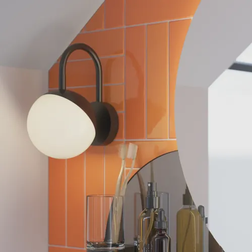 Badezimmer mit schräger Decke, inspiriert durch einen kleinen weißen Waschtisch und einen Hochschrank mit runden schwarzen Griffen, sowie einem schönen runden Spiegel, orangefarbene Fliesen geben einen frischen und modernen Look.