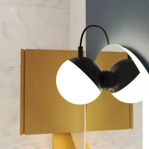 Spiegellampe mit weichen Formen an einer dunkelblauen Wand in einem stilvollen Badezimmer.