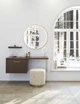 Badezimmer Inspiration im nordischen Stil mit Waschtischunterschrank und Unterschränken aus geräucherter Eiche, Schminkplatz, seitlich montiertem Waschbecken, rundem Spiegel mit Messingrahmen und sichtbaren charmanten Holzbalken.