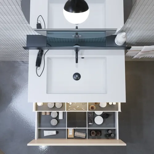 Stilvolle Badezimmer Inspiration mit beigem Waschtischunterschrank mit Innenschublade, Oberschrank, offenem Regal, ovalem Spiegel mit Beleuchtung, passenden Pendelleuchten, Regal unter dem Spiegel und wandhängendem WC.