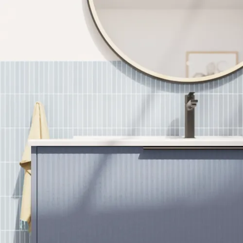 Badezimmerinspiration mit länglichen hellblauen Fliesen und Betonboden, elegantem hellblauem Waschtischunterschrank mit schmalen Streifen, stilvollem und dünnem Waschbecken sowie minimalistischem rundem Spiegel mit schwarzem Rand und Licht.